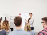 Vrouw geeft een presentatie aan een groep mensen.